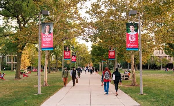 Students walking on campus under campus banners
